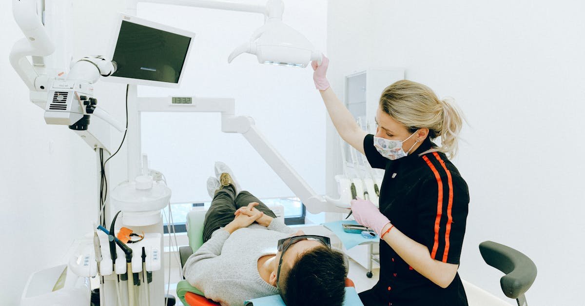 Female dentist examines patient's teeth in modern clinic setting.